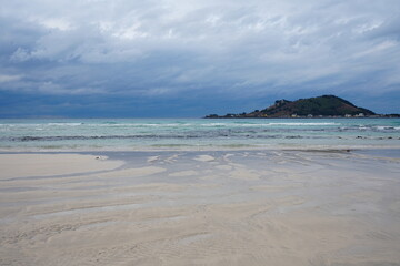 clear shoaling beach and far island