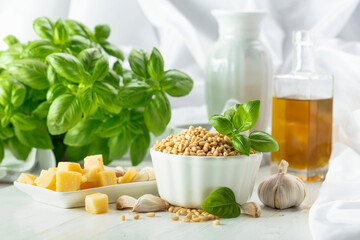 Ingredients for making Pesto sauce on a white wooden table.