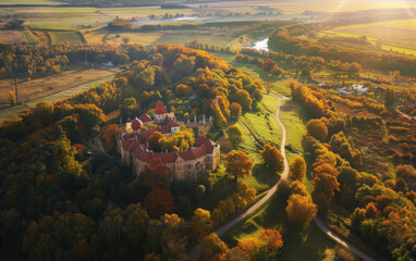 Aerial Views of Vibrant Autumn Forest Showcasing Castles and Churches in Latvia with Red and Orange Trees, Winding Roads, and Rivers, Captured During Golden Hour with Wide-Angle Lenses for a Picturesq