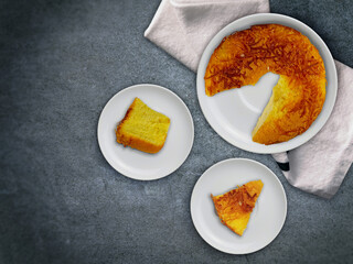 Cheese chiffon cake on a dark background. Flat lay shot. Fluffy freshly baked cheese chiffon cake, perfect dessert during tea time.