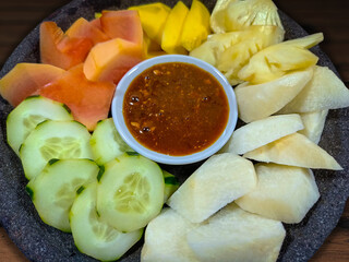 Close up shot of Indonesian fruit salad served with peanut sauce. Also known as rujak buah or lotis. The fruits consist of cucumber, jicama, young papaya, pineapple, and mango.