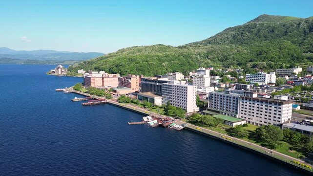 Lake Toya, Hokkaido, Japan: Aerial drone footage of the resort town of Toya Onsen famous for its hot springs and Japanese spa in Hokkaido in summer. 