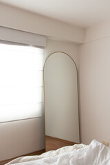 espejo de pie en una habitación con una ventana 
