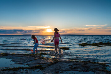 children with nets at sunset by the sea of the Volga river