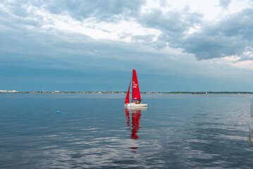 Red sailboat at sea sunset