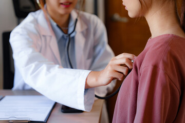 Doctor using stethoscope to check the heartbeat of the patient