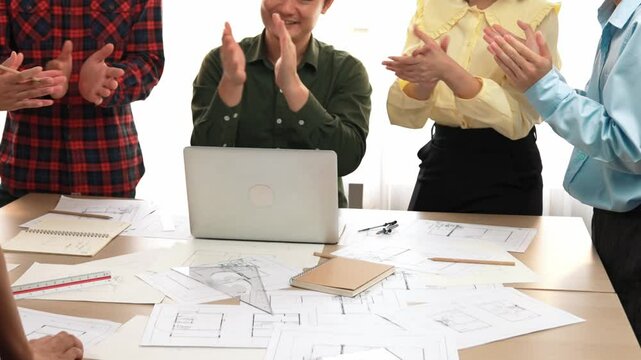 Architect and safety engineer celebrate success design building blueprint project on laptop with architectural document and measurement tool scatter around at modern office. Closeup. Delineation.