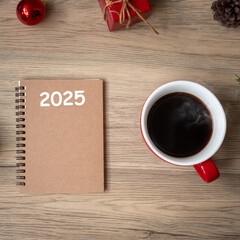 2025 notebook, black coffee cup and Christmas gift on wood table, Top view and copy space. Xmas, Happy New Year, Goals, Resolution, To do list, Strategy and Plan concept