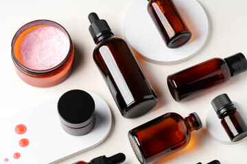 Obraz premium Amber Glass Bottles and Jars of Skincare Products on White Background