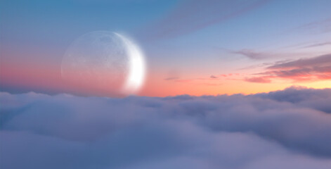 Fototapeta premium Dusk sky with crescent moon over the clouds at sunset