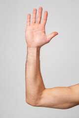 Mans Hand Showing Sign against gray background