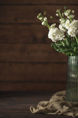 a vase with flowers on a table and a wall behind it