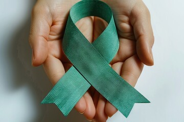 Green handmade awareness paper ribbon on white background.