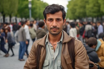A man with a beard stands in a crowd of people