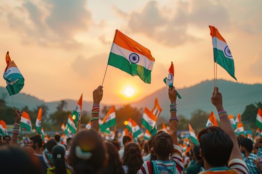 Celebration with Indian flags at sunset with a crowd gathered outdoors.