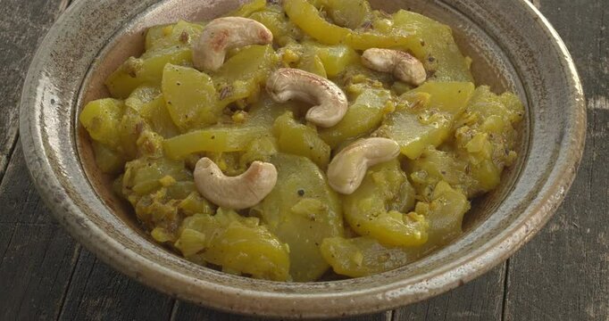 Torai ki sabzi - homemade Pakistani-style zucchini curry  decorated with roasted cashew nuts..