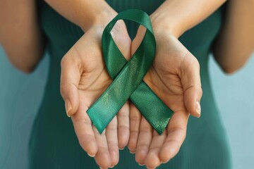 Woman holding green ribbon on color background. Kidneys cancer awareness concept