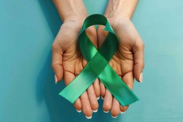 Woman holding green ribbon on color background. Kidneys cancer awareness concept
