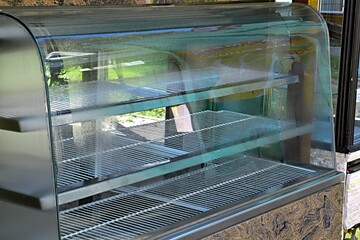 Empty refrigerated display case in a cafe closed at the end of the season