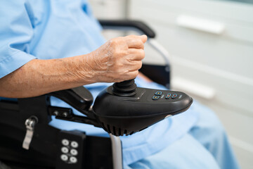 Asian senior woman patient on electric wheelchair with remote control at hospital, healthy strong medical.