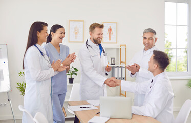 Team of positive doctors and nurses engages in a handshake during a productive meeting in the...
