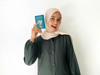A standing woman with smiling face holding Indonesian passport isolated on white background....