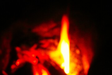 Wooden logs are burning in the fireplace. close-up. Tongues of flame on a dark background.