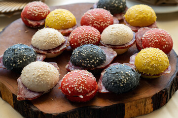 Delicious mini sandwiches with salami and colored bread buns