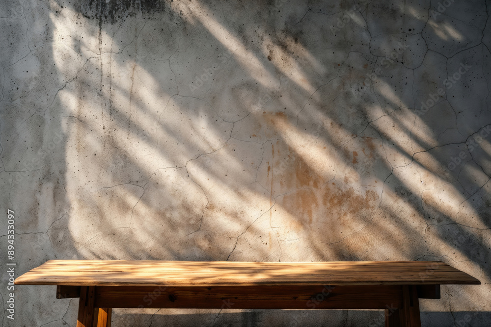 Poster Empty wooden table is presenting product display on cracked concrete background illuminated by sunlight and shadow
