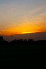Sunset Sky cloud in the Morning Sunrise with Orange, Yellow Golden Hour Sunrise on Summer season, Horizon Dusk Sky Dramatic Nature Background