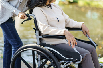 Obraz premium Nursing home. Young caregiver helping senior woman in wheelchair.