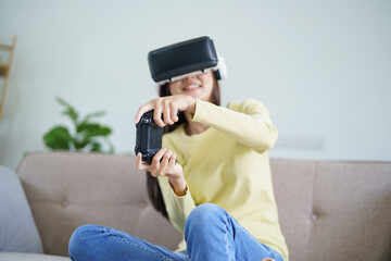 Fototapeta premium Young Asian woman gamer wearing virtual reality touching air during the VR experience Future home technology player hobby playful enjoyment concept.