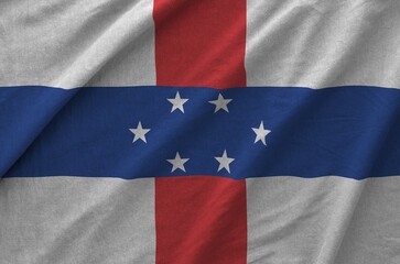Netherlands Antilles flag depicted on folded wavy fabric of old cloth close up