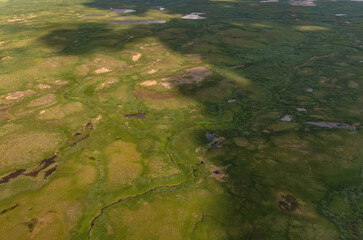 Arctic tundra in summer from an altitude of 2000 meters. Variety of colors and landscapes. The vastness of pristine nature. Shadow from clouds