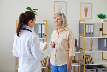 Obraz premium Caring young female nurse talking, doctor caretaker consult assisting senior, helping old patient in clinic rehabilitation recovery during medical checkup visit, elder people clinician healthcare