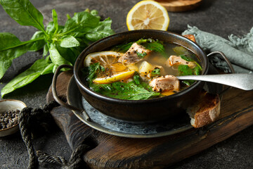bowl of salmon and spinach soup on a dark table