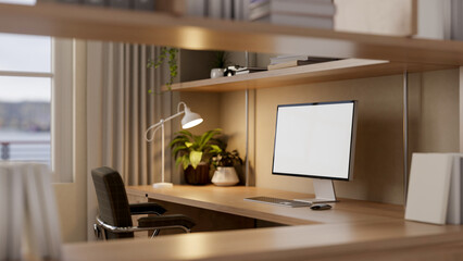 A computer with a white-screen mockup on a wooden desk in a cozy home office.