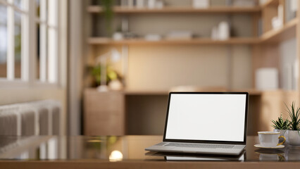A laptop with a mockup screen on a modern coffee table in a cozy private office workspace.