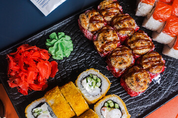 Japanese food: sushi and a variety of rolls on a black plate. Japanese restaurant menu, sushi delivery. Selected focus
