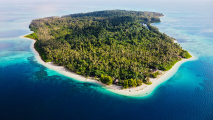 An aerial view of Sumatra's island Sikandang, showcasing the stunning contrast between lush tropical forests and vibrant turquoise waters. A paradise waiting to be explored.
