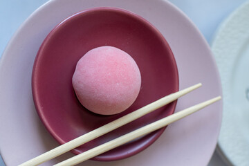 Pink mochi dessert with cream filling and berry. Sweet food