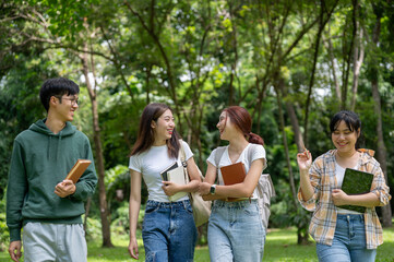 A group of cheerful Asian students are enjoying talking and laughing while walking in the park.