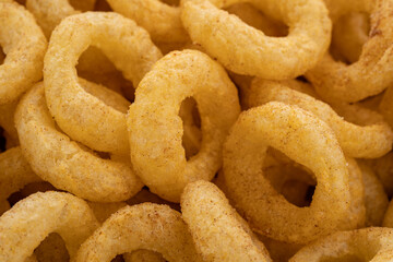 Crispy ring snacks isolated on white background. Corn onion rings in bowl isolated on white background. Crispy onion rings, isolated on white background. Snacks for watching movies.