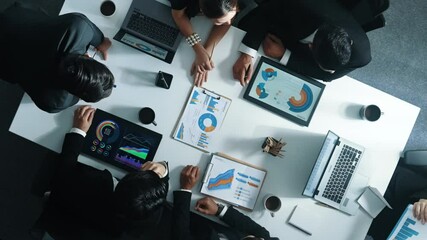 Top view of diverse business people brainstorm marketing idea and plan strategy. Professional businessman standing at whiteboard and explain financial plan while look at graph on table. Directorate.