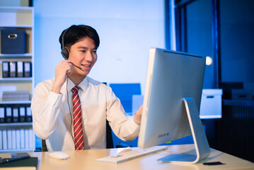 erious call center operator in wireless headset talking with customer, Asian man with microphone consulting client