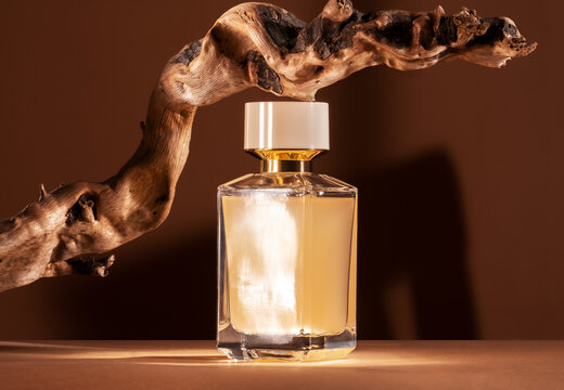 Presentation of perfume with wooden notes on brown background.