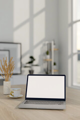 A close-up image of a laptop computer mockup on a wooden table in a minimalist white room.