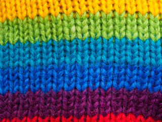 Close-up of bright multi-colored knitted wool fabric. Detailed textures and rich colors highlight the quality and appeal