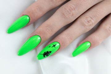 A bright green manicure, just done in a beauty salon, on the fingernails. Close-up of manicured hands