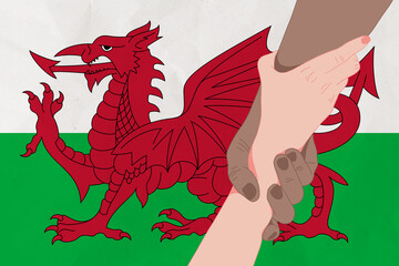 Helping hand against the Wales flag. The concept of support. Two hands taking each other. A helping hand for those injured in the fighting, lend a hand